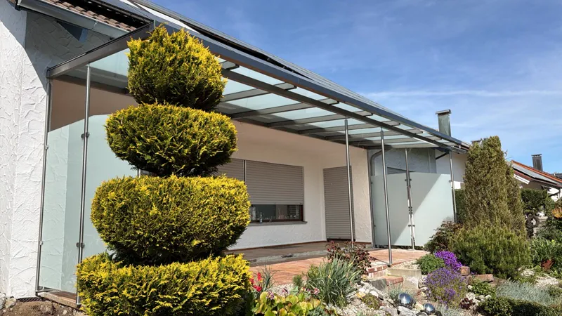 Terrassenüberdachung aus Edelstahl mit Glasdach und satiniertem Windschutz